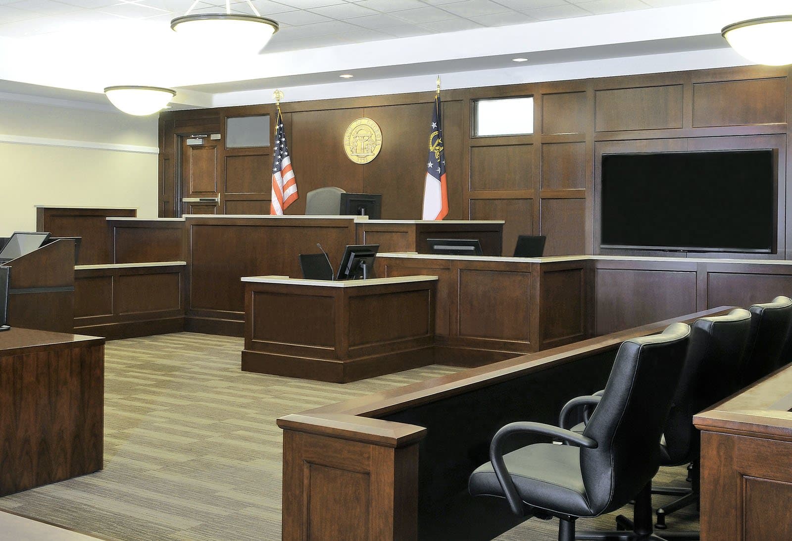 Inside of courtroom with judges bench, American flag, and Georgia state flag.