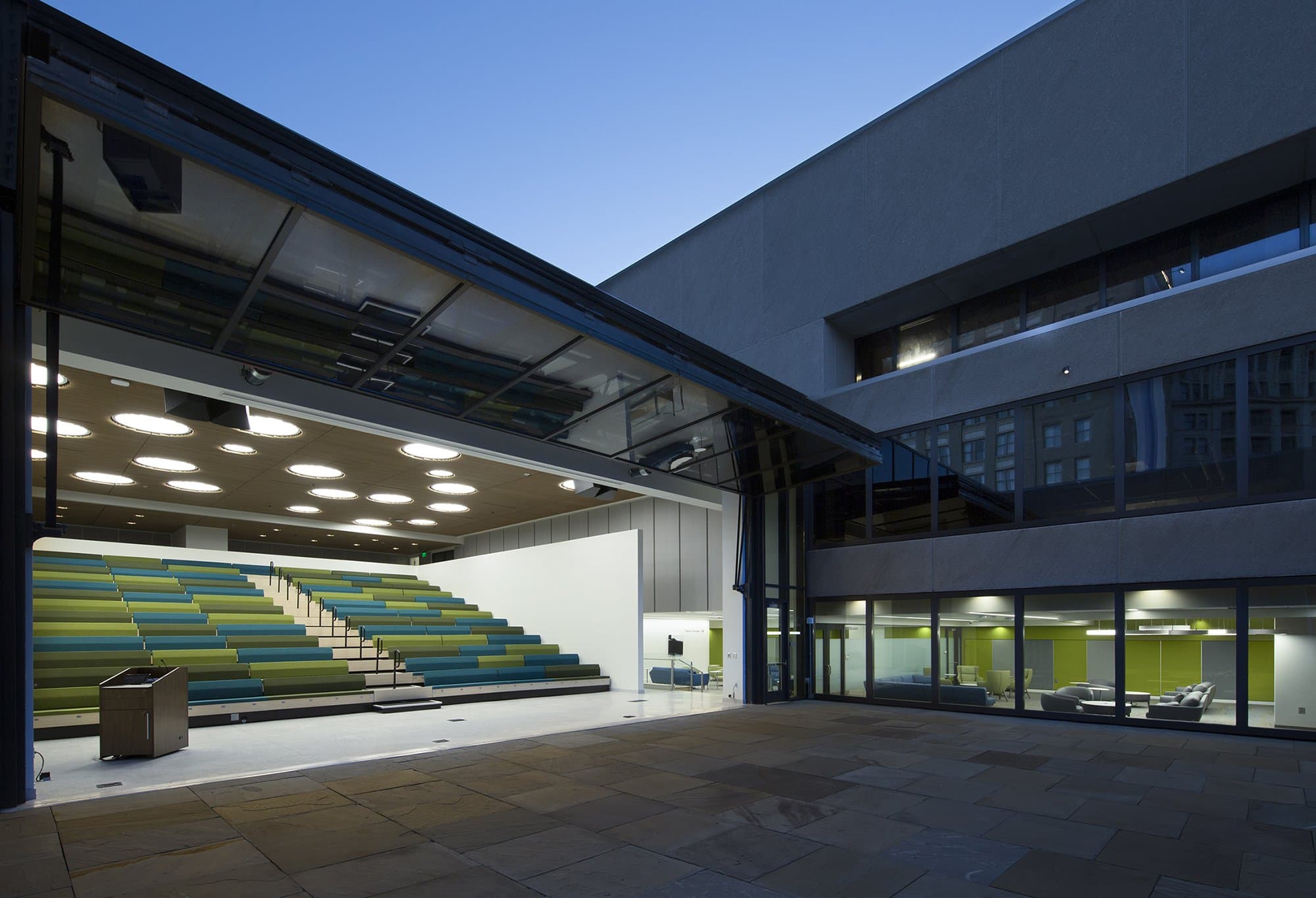Nighttime image of auditorium seating with wall open to the outdoors.