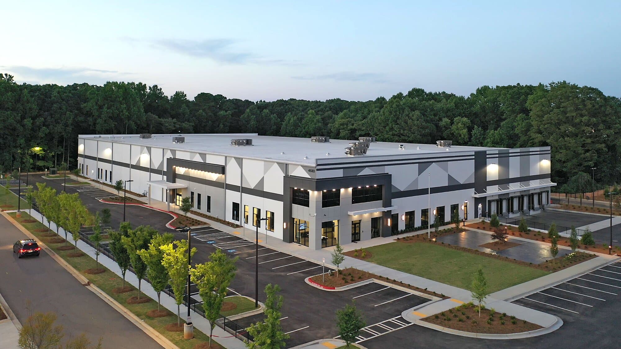 Exterior image of the building  with large windows, flagpole, and landscaping.