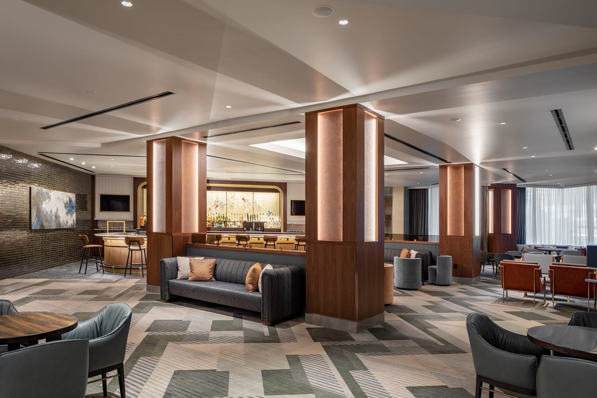 The lobby of a hotel with modern furniture and a fireplace.