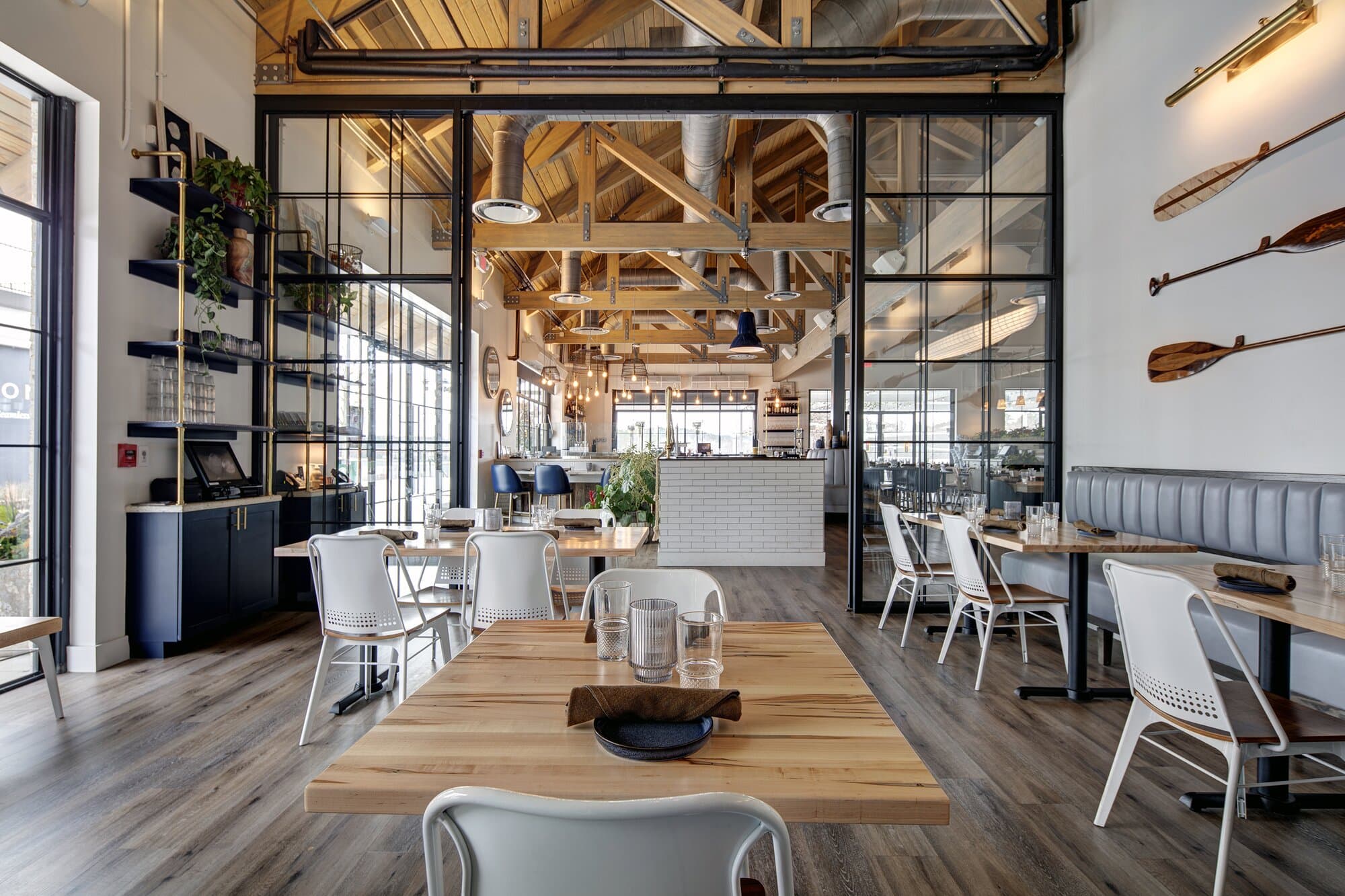 Seperate room inside of restaurant offering a more intimate place for families or meetings. Black metal and glass doors from floor to ceiling, additional seating and tables.