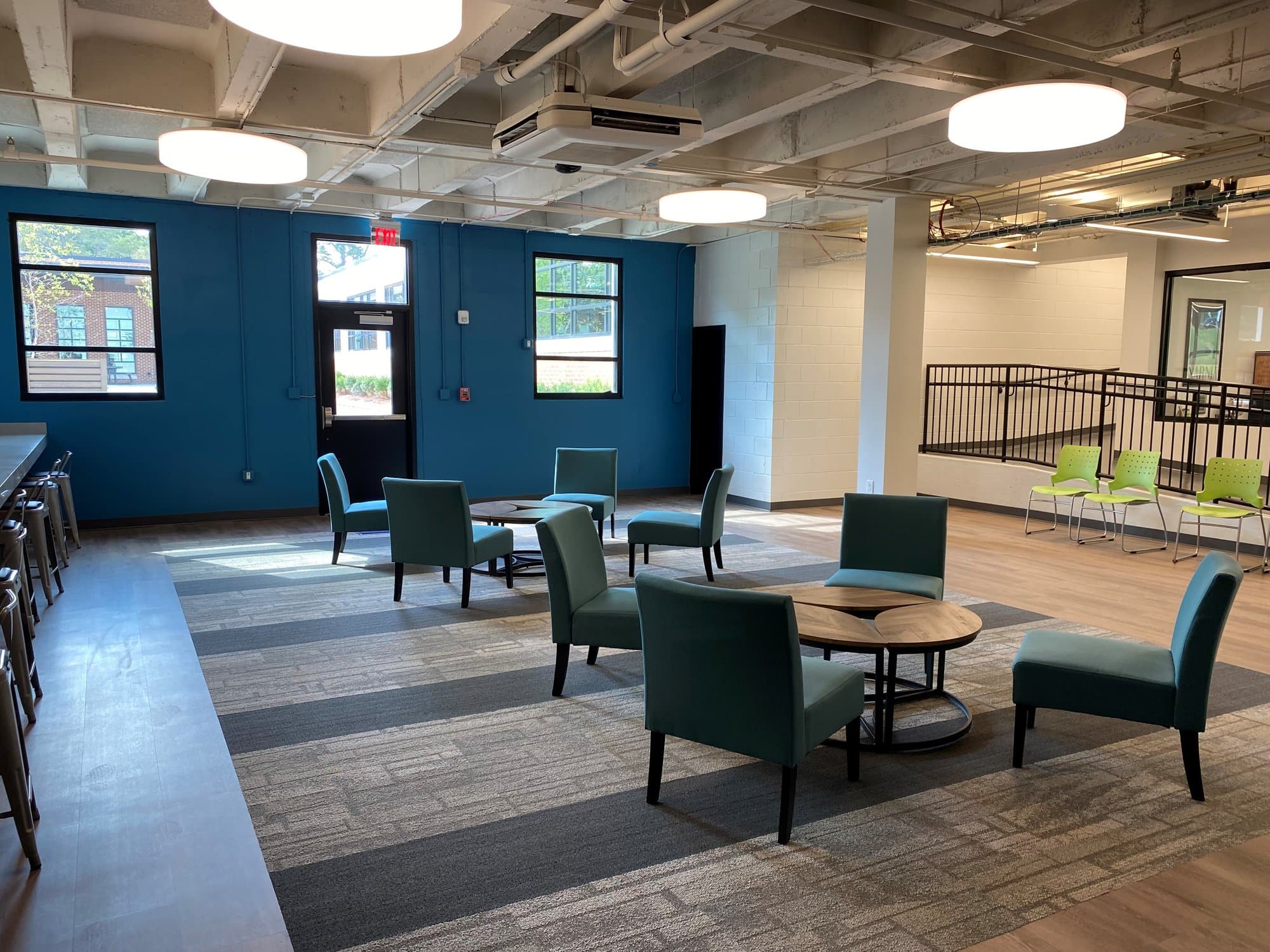 A blue accent wall seen behind tables and chairs in a relaxing work environment.