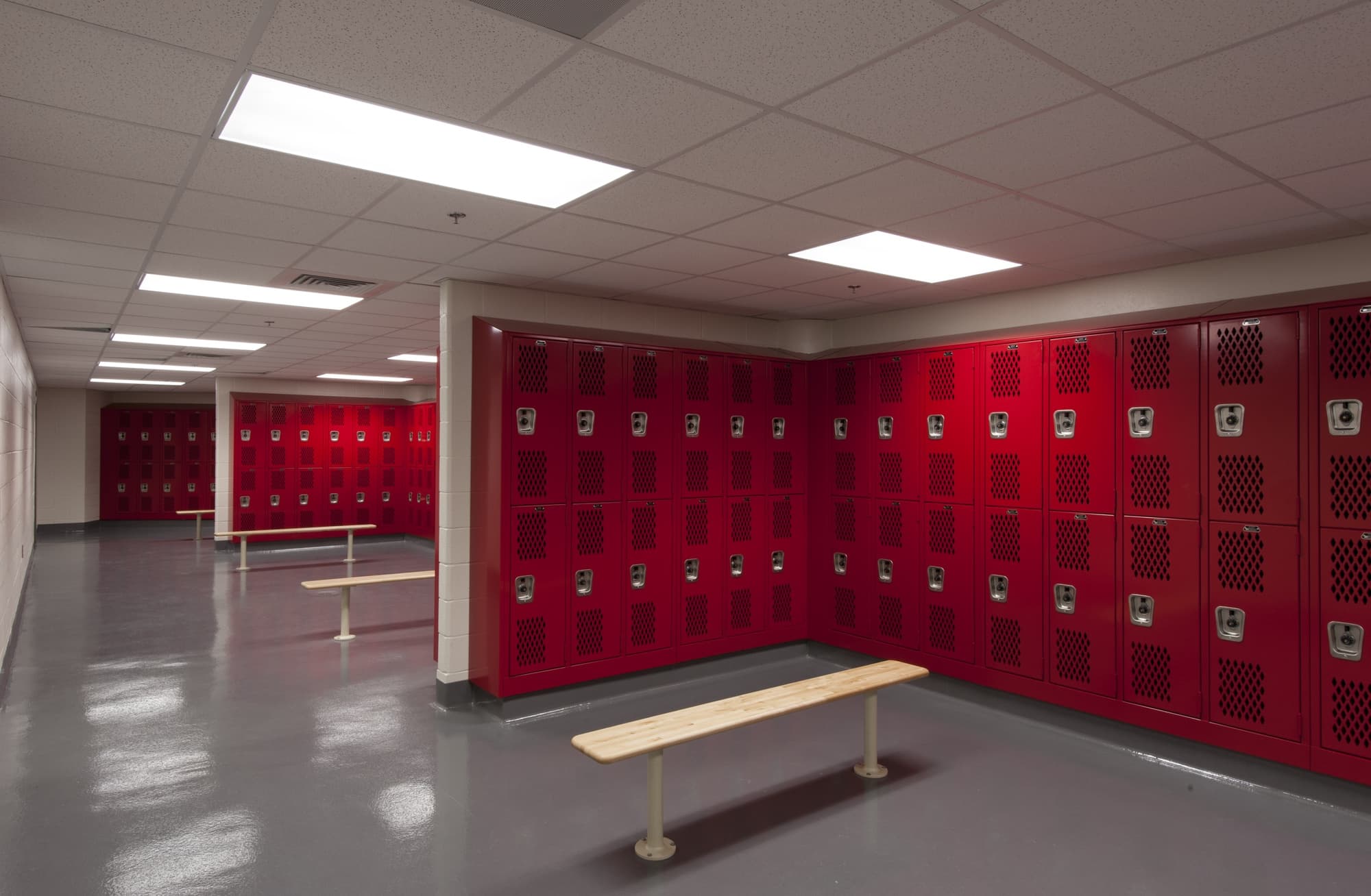 Image of locker room with red lockers and benches.