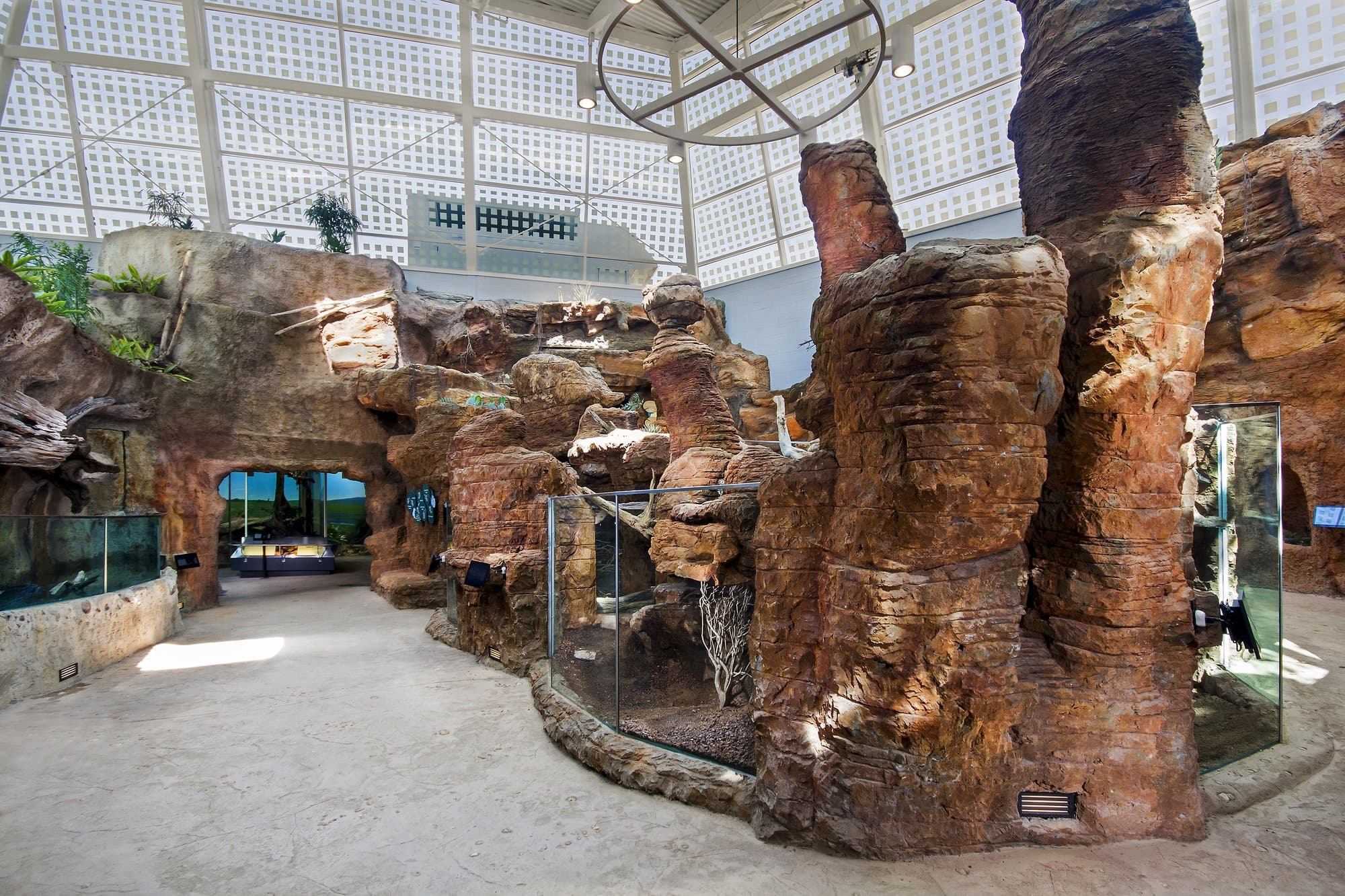 A reptile exhibit in a zoo with a lot of rocks in it. 	