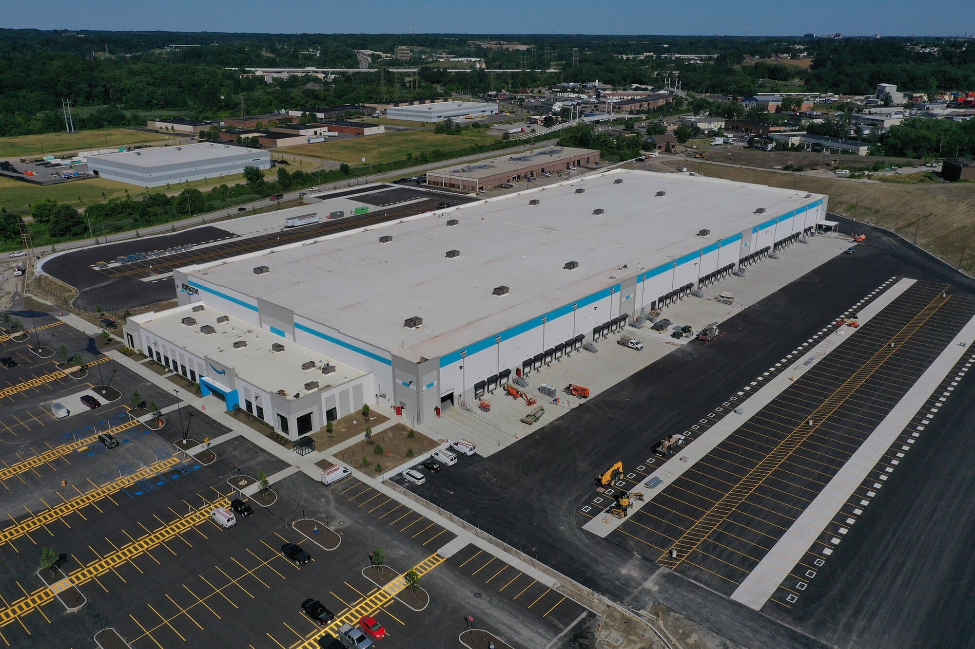 Aerial image featuring warehouse, parking lot, and surrounding area.