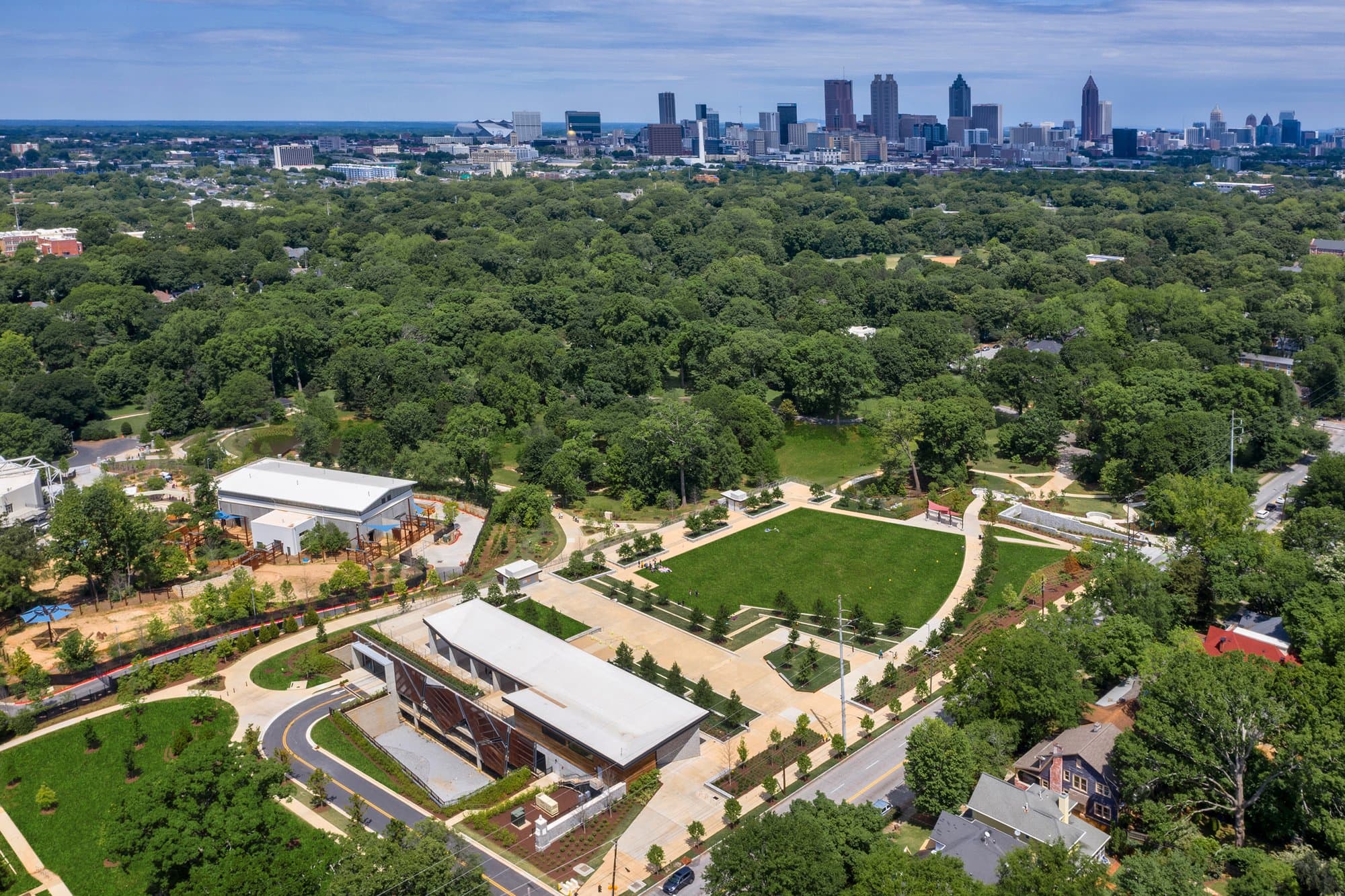 Areial image of parking garage under grassy open park with Atlanta skyline in the distance.